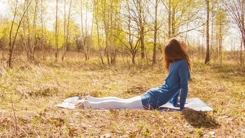 Young woman practicing yoga in a spring forest. Video stock 80615153