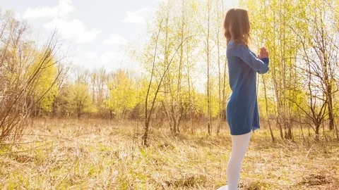 Young woman practicing yoga in a spring forest. Video stock 80615162