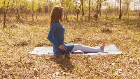 Young woman practicing yoga in a spring forest. Video stock 80615246