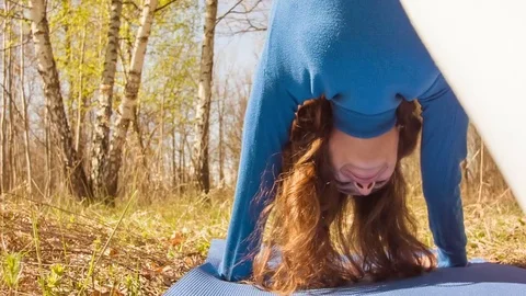 Young woman practicing yoga in a spring forest. Video stock 80643982