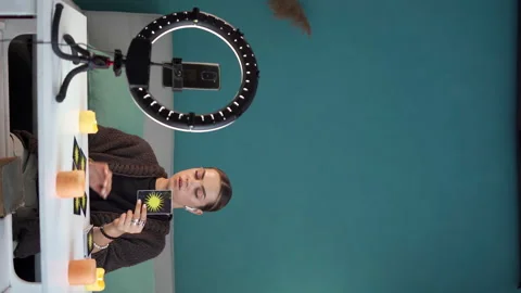 Young woman predicting the future and showing tarot card while being recorded on Stock Footage 253784313