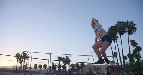 Young woman preforms slackline tricks on beach during sunset, backflip Video stock 73491802