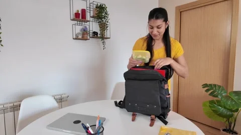 Young woman preparing backpack for work or school Stock Footage 307187672