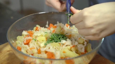 Young woman preparing vegetable salad in the kitchen, shoot close up. Stock Footage 74560159