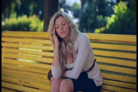 Young woman problems, depression, headache sad sits in park Stock Footage 28463802