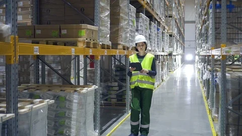 Young woman professional using tablet during working day at factory warehouse. Video stock 123225354