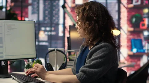 Young woman programming software code on her computer Stock Footage 308604109