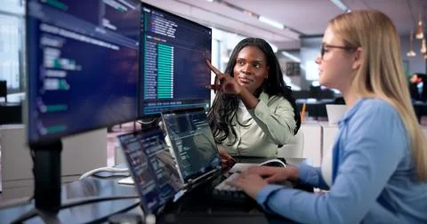 Young Woman Programs Code On Her Laptop In A Bright Workspace. Stock Photos