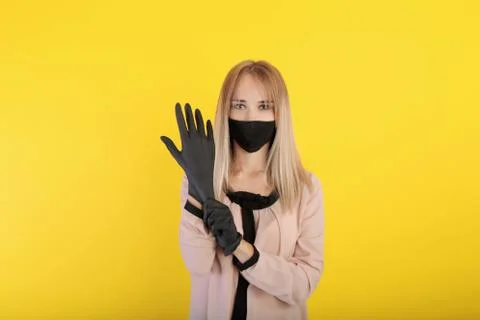 Young woman in a protective face mask and medical gloves. a woman in a medica Photos