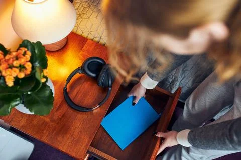 Young woman pulling diary from bedside drawer. Writing journal Stock Photos