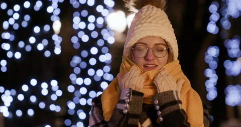 Young woman pulls down orange scarf from face looking ahead Stockbeeldmateriaal 206096720