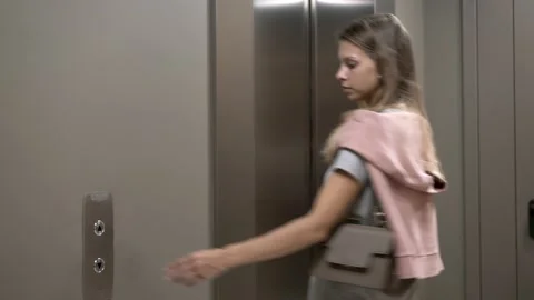 Young woman push the button on elevator, getting into Stock Footage 137638935