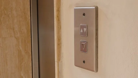 Young woman pushes elevator button to go down. Elevator button push Stock Footage 106472644