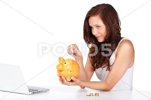 Young woman putting coins in her piggy bank Stock Photos