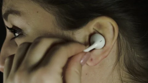 Young Woman Putting Headphones Earbud In Ear To Talk  Vídeos de archivo 59559244