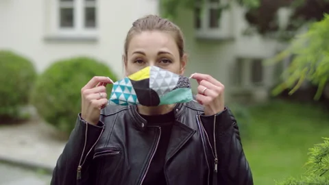 Young woman is putting her colorfull cloth mask on. Stock Footage 131544853