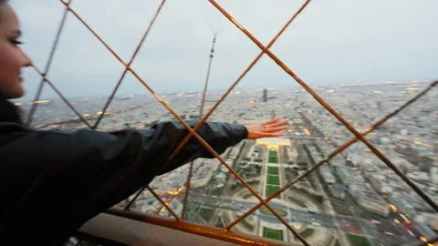 Young woman reaching Eiffel Tower summit floor with Paris city views Stock Footage 243280198