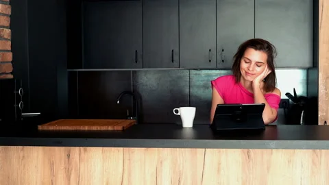 Young woman read something on tablet in the kitchen Видео 92829349