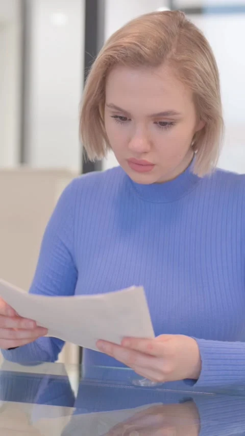 Young Woman Reading Documents at Work, vertical video Video stock 325578438