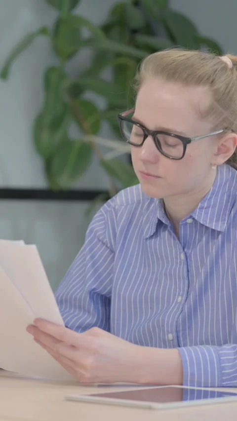 Young Woman Reading Documents at Work,  Paperwork, vertical video Vídeos de archivo 328548806