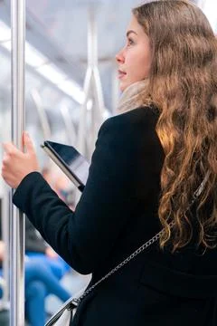 Young Woman Reading on E-Reader While Commuting on Subway.Vertical Stock-Fotos