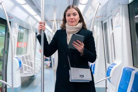Young Woman Reading on E-Reader While Commuting on Subway Stock Photos