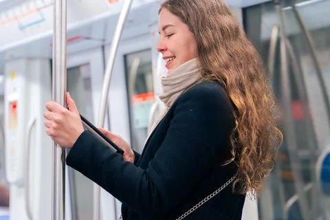Young Woman Reading on E-Reader While Commuting on Subway Stock Photos