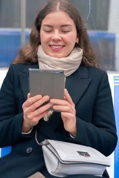 Young Woman Reading on E-Reader While Commuting on Subway Train.vertical Stock-Fotos