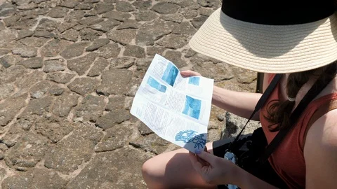 Young woman reading a map exploring Lanzarote 動画素材 127128472