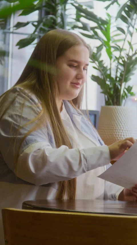 Young Woman Reading Menu While Sitting In Green Cafe Stock Footage 334935891