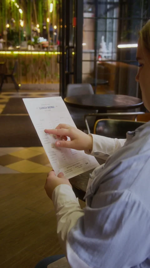 Young Woman Reading Menu While Waiting For Waiter In Restaurant Stock Footage 334936234