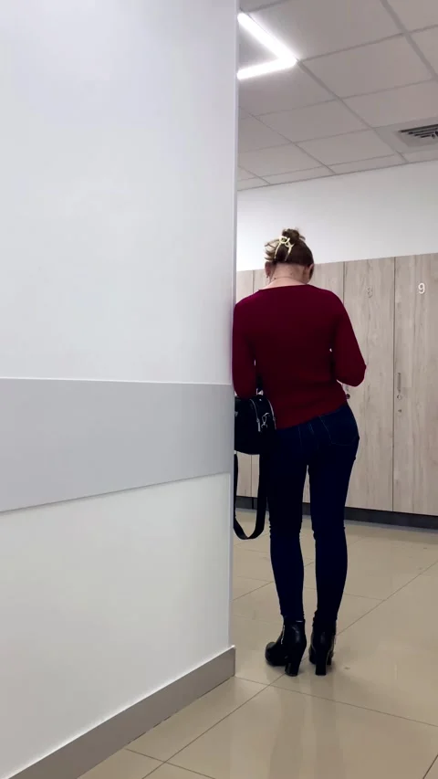 Young woman reading message using mobile phone while standing near wall in Stock Footage 293367223