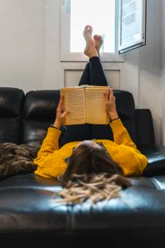 Young woman reading on the sofa Stock Photos