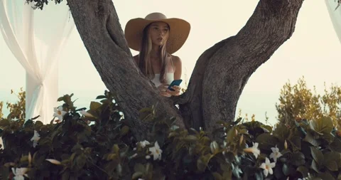 A young woman reads a message on her cell phone and looks around eagerly Stock-Footage 284016853