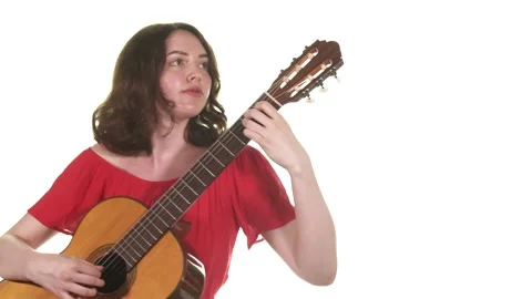 Young woman in a red blouse playing the classical acoustic guitar. Isolated Stock Footage 133330853