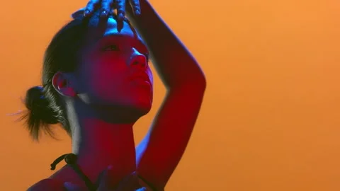 Young woman in red blue led turns face hand over head Stock-Footage 339402353