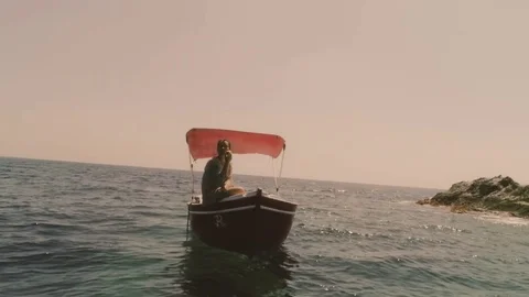 Young woman on a red boat in the middle of the ocean Stock Footage