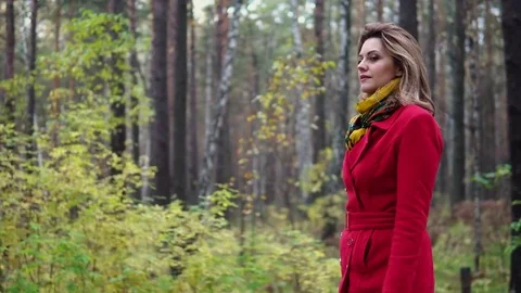 Young woman in a red coat walking along an autumn park. beautiful girl enjoying Stock Footage