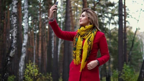 Young woman in a red coat walking along an autumn park. beautiful girl enjoying Stock Footage