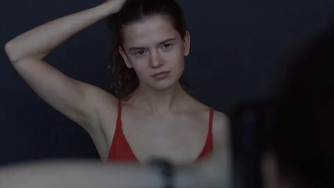Young woman in red dress posing indoors backstage photoshoot 4k. Stock Footage 104717853
