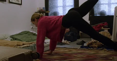 Young woman refugee does exercise on floor in shelter 스톡 동영상 172023215