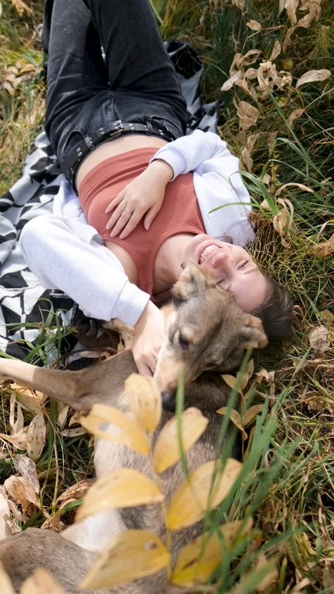 Young woman relaxes while walking her dog in autumn forest Stock-Footage 313681017