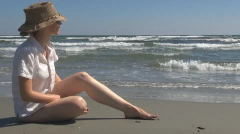 Young woman relaxing on the beach, sitting, nature, holiday, ocean, sea sand Stock Footage