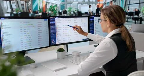 Young Woman Resolves IT Support Tickets Using Helpdesk Software On Computer. Stock Photos