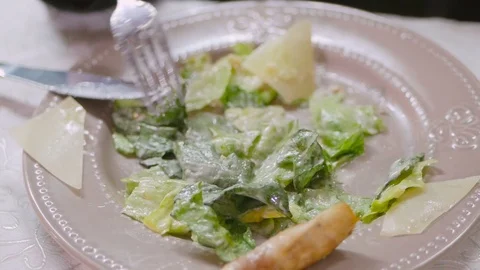 Young woman in restaurant eats caesar salad Stock Footage 98512829