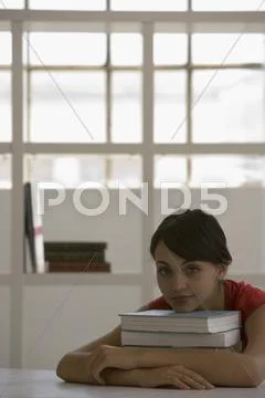 Young woman resting chin on books Stock Photos