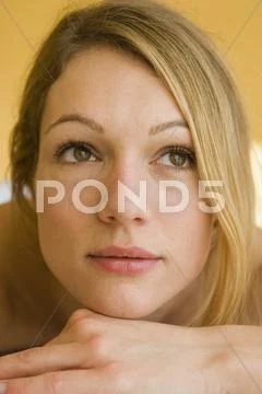 Young woman resting chin on hand Stock Photos
