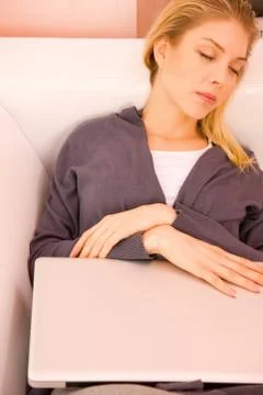 Young woman resting sofa while using laptop Stock Photos