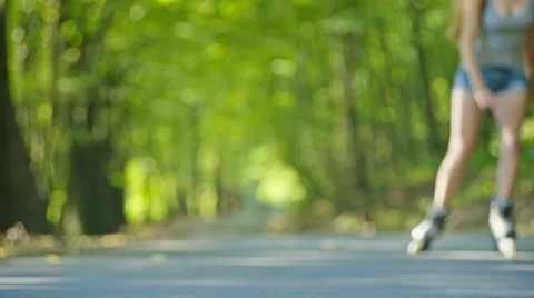 Young woman roller skating through a summer forest Stock Footage