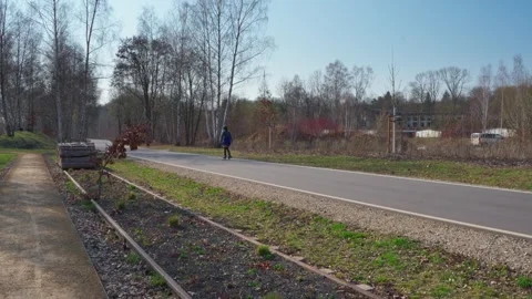 Young woman rollerblading on a park path in spring Stock Footage 331084183